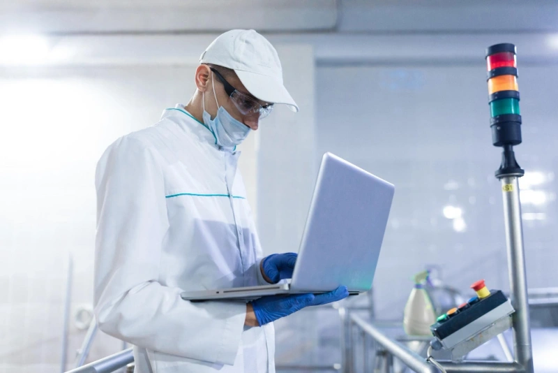 Process engineer reviewing MES data on the factory floor—closed-loop PCBA quality control with AI analytics.