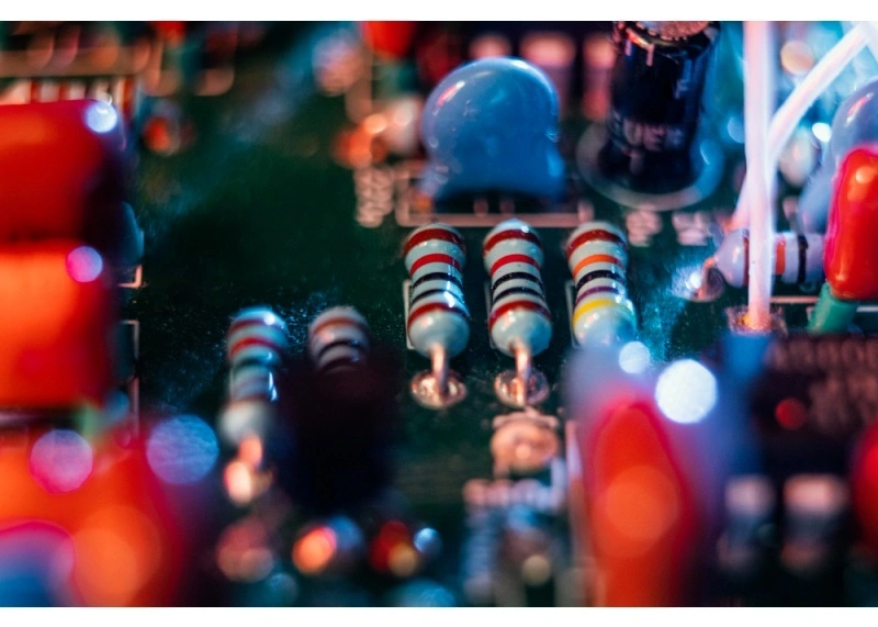 Macro of resistors and capacitors on a PCBA; small passives where tombstoning risk and thermal balance matter